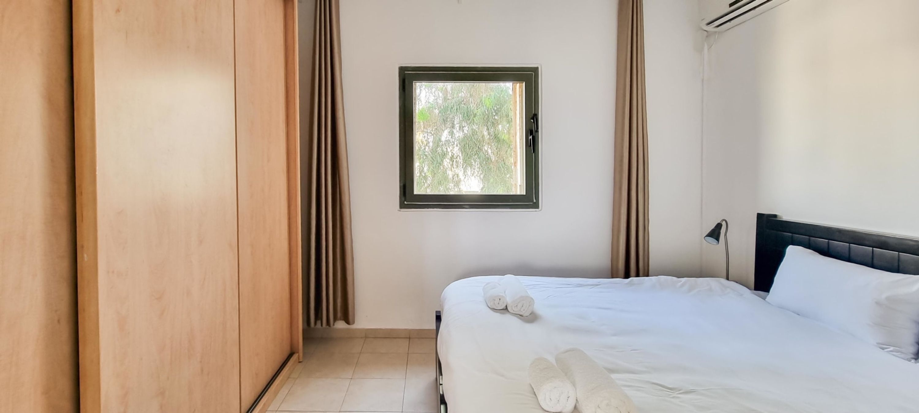 Une chambre à coucher avec un lit, une fenêtre et une armoire.