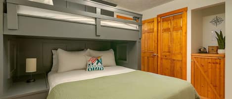 A bunk bed with a headboard, a bedside lamp, and a pillow with a hockey logo.