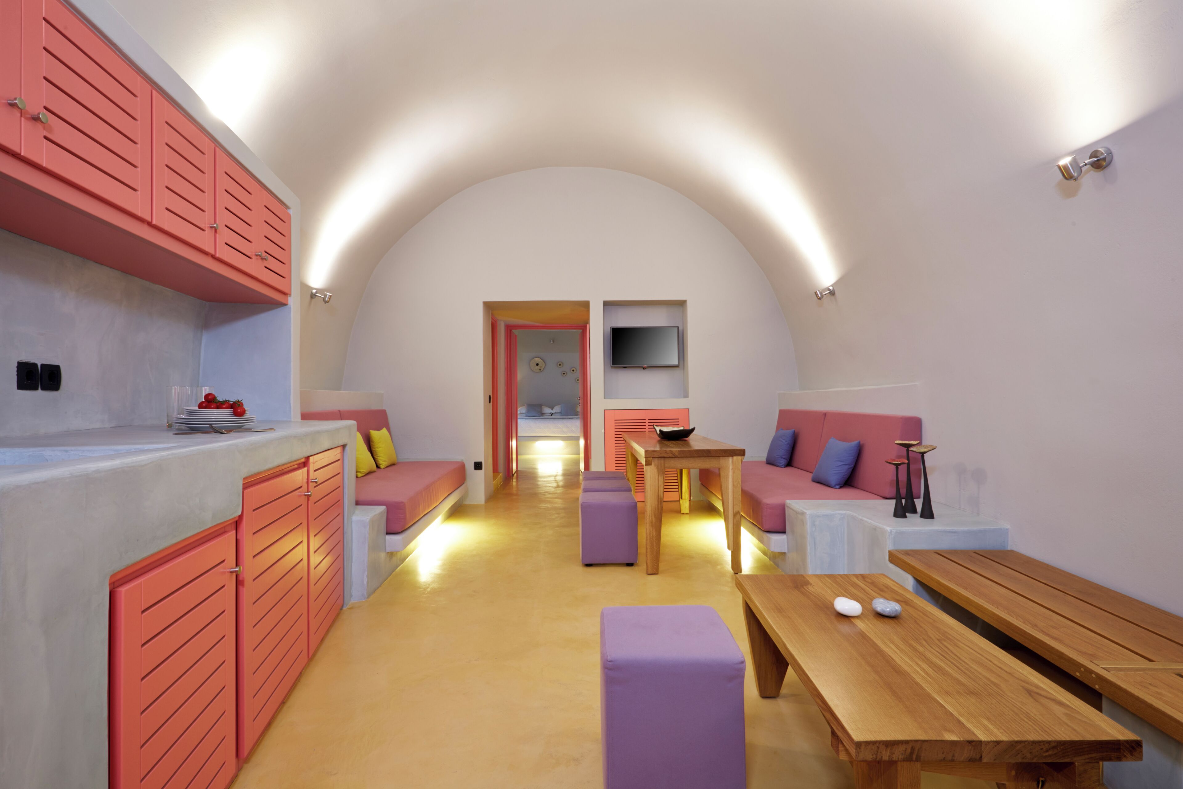 A compact, modern living space with a kitchen area, a dining table, and seating arrangements.
