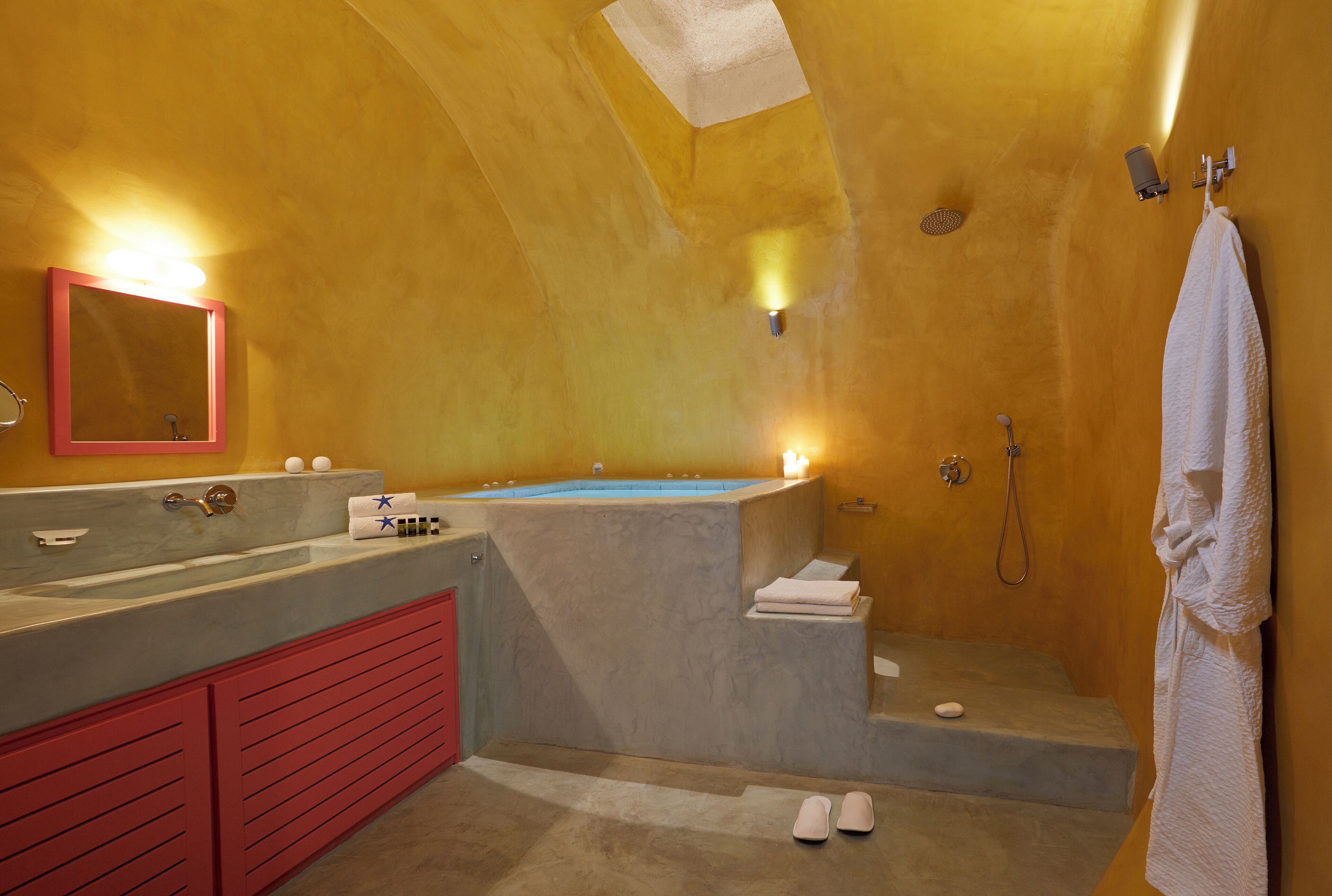 Un baño con una bañera grande, una zona de ducha separada y un tocador con espejo.