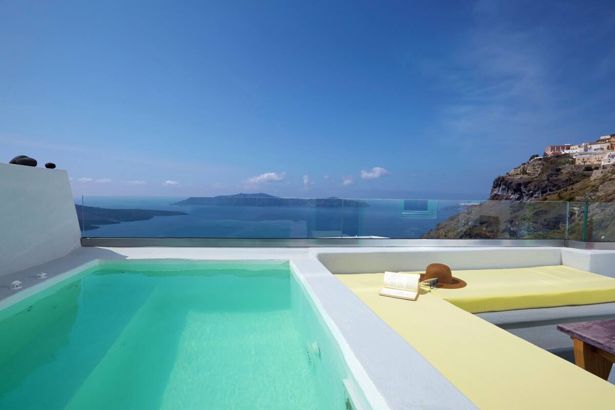A rooftop infinity pool with a clear view of the sea and distant islands.
