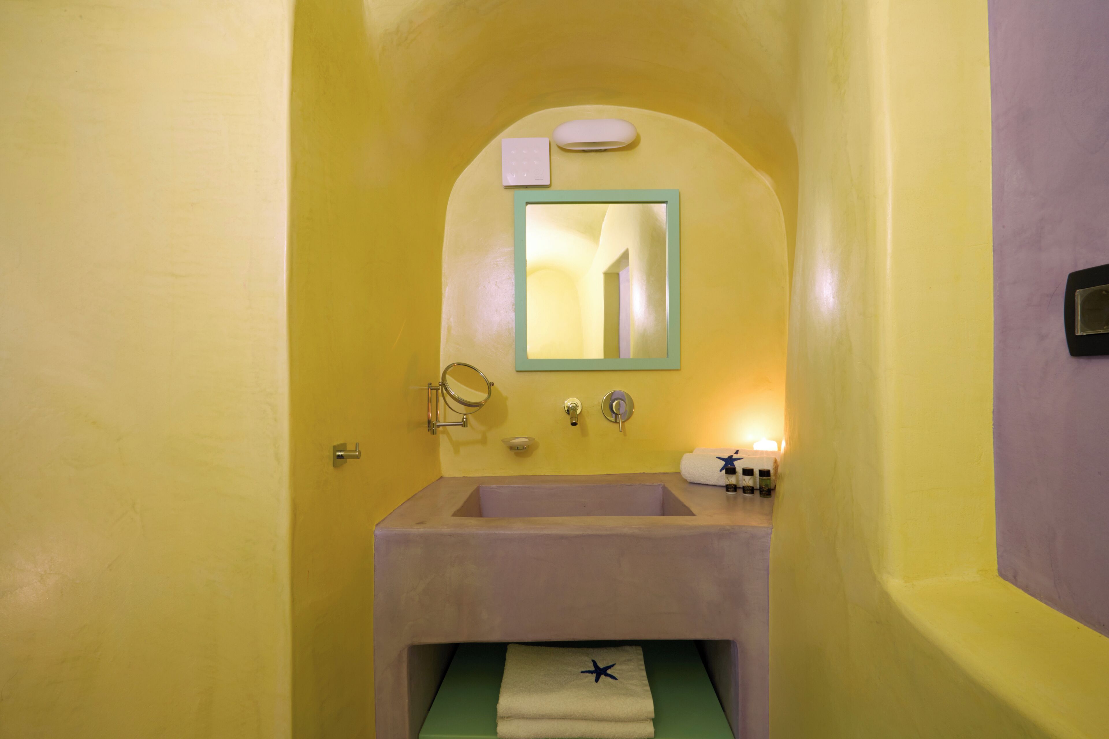 A bathroom with a sink, mirror, towel rack, and a towel with a star design.