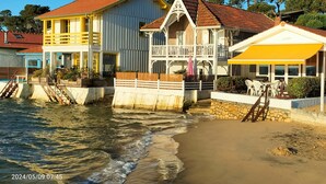 Edificio sul lungomare con balcone, piscina e spiaggia.