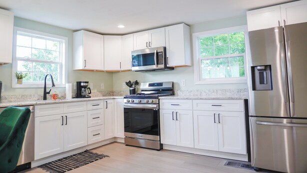 A modern kitchen with white cabinets, stainless steel appliances, and a window providing natural light. - Charming 3-bedroom house in enjoyable Endwell (Endicott)