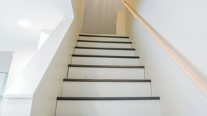 A modern staircase with wooden handrails and white walls. - Charming 3-bedroom house in enjoyable Endwell (Endicott)