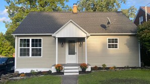 A two-story house with a front porch, a satellite dish, and a garage. - Charming 3-bedroom house in enjoyable Endwell (Endicott)