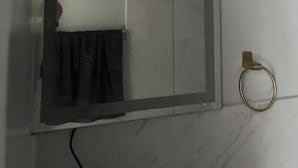 Een badkamer met een grote spiegel, een handdoekhouder en een deur.