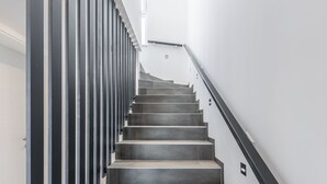 A modern staircase with a sleek design, featuring a metal railing and a straight flight of steps.