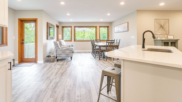 A spacious kitchen with a dining area, wooden flooring, and large windows. - Family-Friendly ‘Lakeview Cottage’ w/ Deck & View (Yankton)
