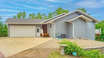 A single-story house with a garage, a front porch, and a small deck.