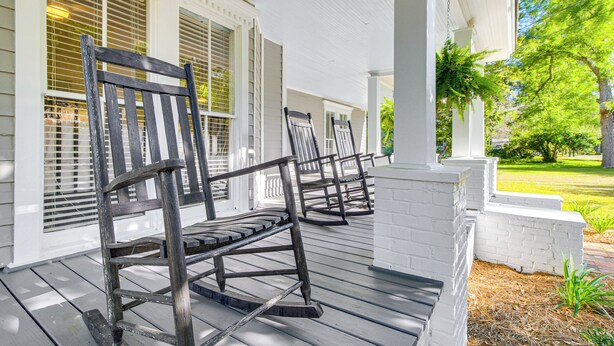 A porch with white columns and wooden rocking chairs. - Charming Georgia Cottage ~ 19 Mi to Statesboro! (Metter)