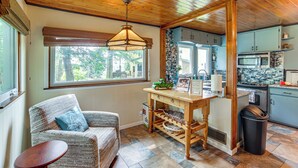 Un salon chaleureux avec un canapé en osier, une table en bois et une fenêtre donnant sur l’extérieur.