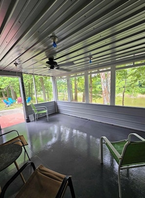 Relax in a serene outdoor space with a view of lush greenery and a tranquil body of water.