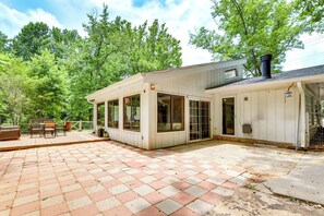 A house with a patio area featuring a checkered tile floor, a wooden deck with outdoor furniture, and large windows. - Walk to Parks & Dining! Alpharetta Family Home (Alpharetta)