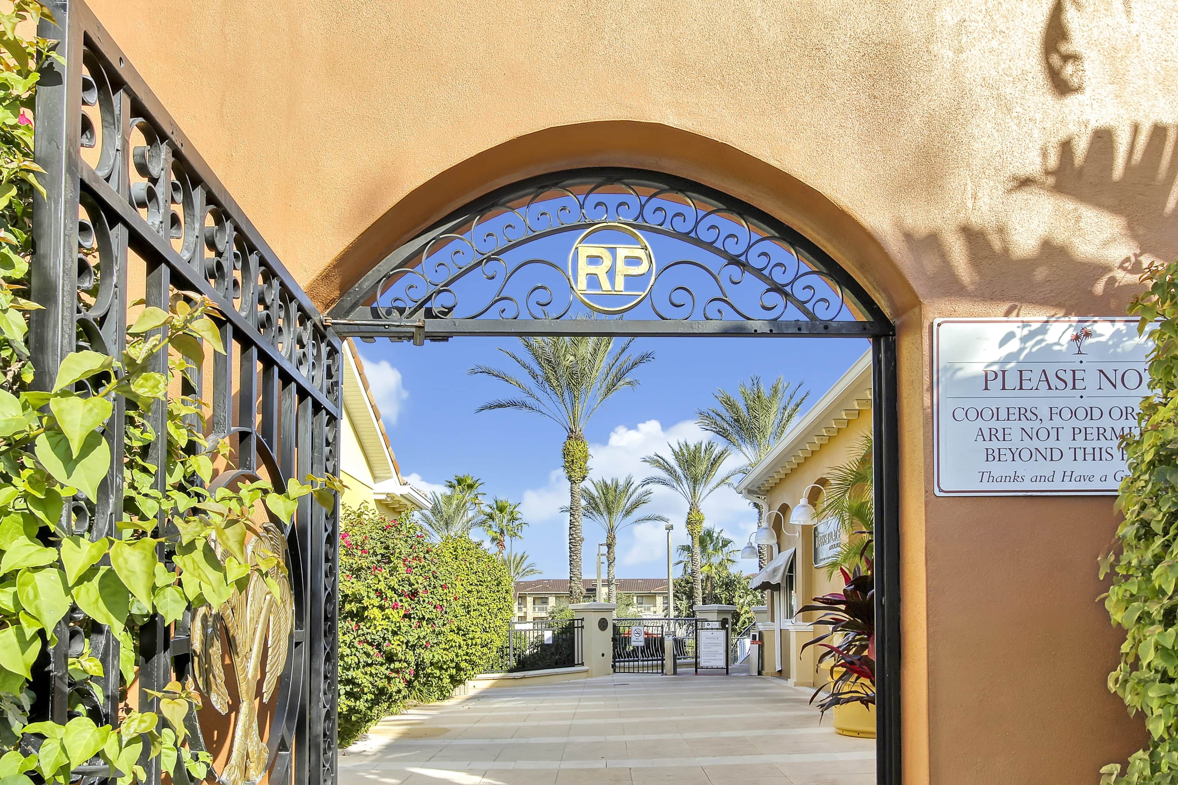 A gated entrance with a sign indicating no coolers or food orders beyond the gate.