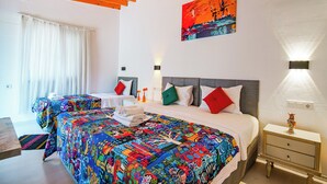 Habitación de hotel con una cama grande, dos mesitas de noche, una lámpara y un cuadro en la pared.