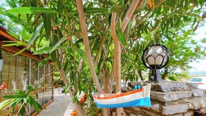 Una barca pequeña colgada de un árbol, un muro de piedra y un farol.