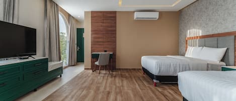 Une chambre d’hôtel moderne dotée d’un grand téléviseur à écran plat, de deux lits, d’un bureau et offrant une vue sur la verdure grâce à une grande fenêtre.