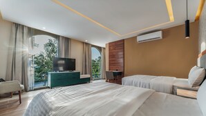A modern hotel room with a large bed, a TV, a desk, and a view of the outdoors. - Hotel Chariot (Mérida)