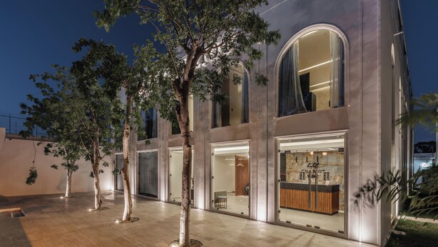 A modern building with large windows and a well-lit entrance. - Hotel Chariot (Mérida)