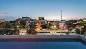 A large building with a prominent tower, surrounded by trees and a clear sky. - Hotel Chariot (Mérida)