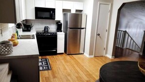 A modern kitchen with white cabinets, stainless steel appliances, and a wooden floor. - Spacious Douglasville/Lithia Springs Retreat: 5BR, 3BA for Families or Business (Lithia Springs)