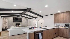 Een moderne keuken met een centraal eiland, houten kastjes en een inbouwvaatwasser.