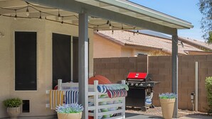 A backyard with a swimming pool, a barbecue grill, and a covered patio area. - Spacious Retreat w/ Free Heated Pool – Close to Stadium & Ballparks! (Peoria)