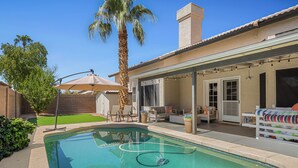 A residential backyard with a swimming pool, patio furniture, and a covered outdoor seating area. - Spacious Retreat w/ Free Heated Pool – Close to Stadium & Ballparks! (Peoria)