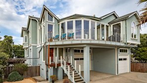 Une maison à deux étages dotée d’un balcon, d’un garage et d’un escalier menant à l’étage supérieur.