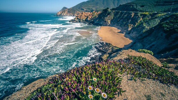 A coastal landscape with a beach, rocky cliffs, and vegetation. - Seaside Escape: 1 block to Beach, Private Hot Tub, Fire Pit & BBQ (El Granada)