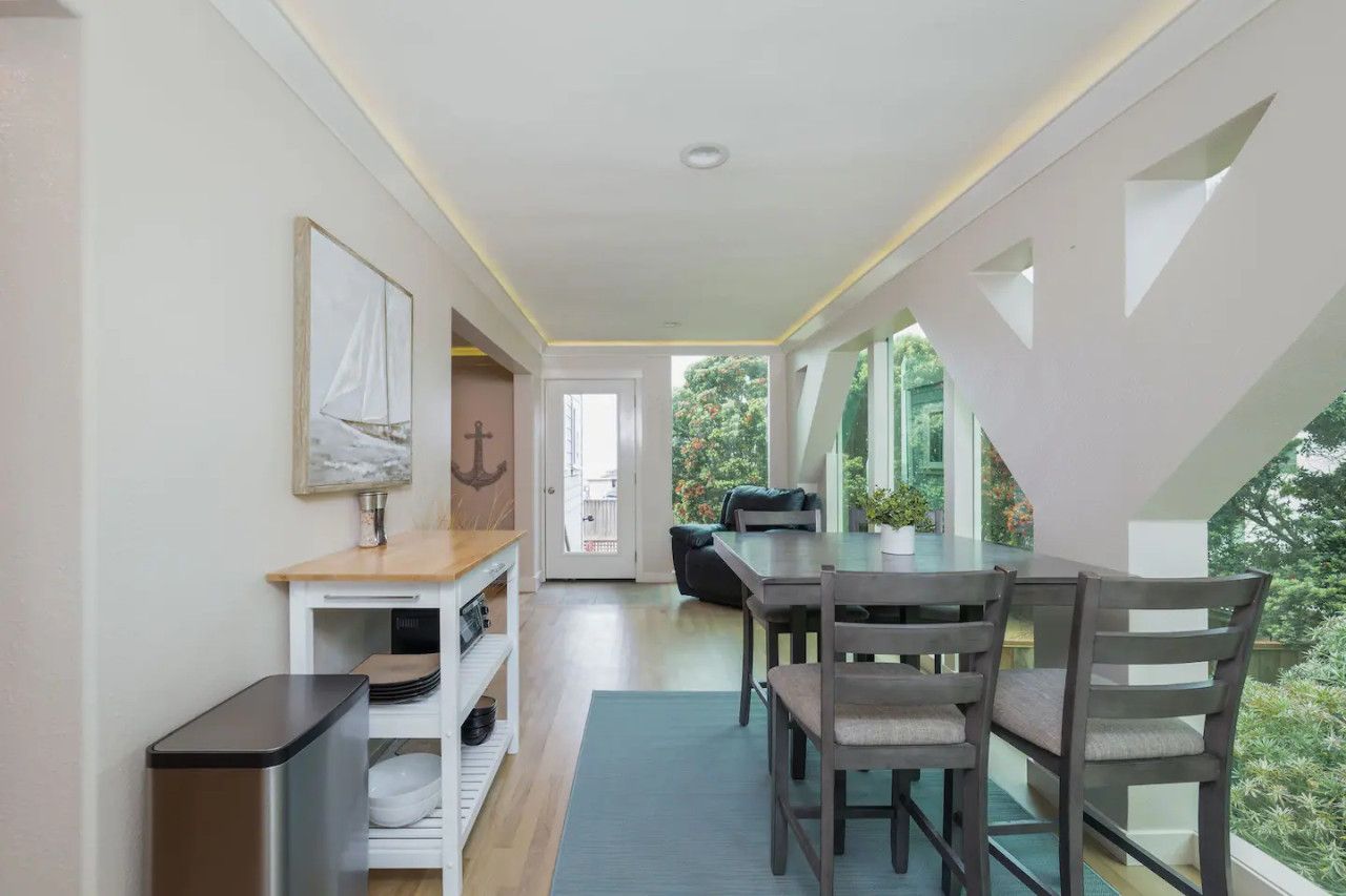 Un intérieur moderne comprenant un coin repas, un comptoir de cuisine et une vue sur la verdure.