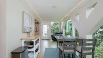 Un intérieur moderne comprenant un coin repas, un comptoir de cuisine et une vue sur la verdure.