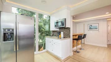 A modern kitchen with a stainless steel refrigerator, a microwave, and a built-in coffee machine.