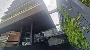 A modern building with multiple balconies, large windows, and a green wall with plants. - URBAN TAMBAU Flat by Penareia.tur.br (João Pessoa)