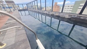 A rooftop pool with clear glass walls, metal railings, and a tiled floor. - URBAN TAMBAU Flat by Penareia.tur.br (João Pessoa)