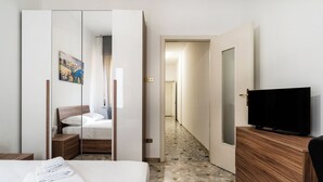 Ein Hotelzimmer mit einem Bett, einem Fernseher, einer Holzkommode und einem Spiegel.