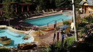 A pool area with a hot tub, lounge chairs, and a pergola. - Antlers Condominiums - Vail (Vail)