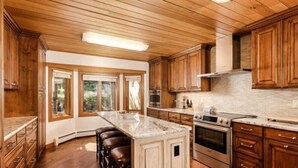 A kitchen with wooden cabinets, a large island, and a built-in oven. - Snowmass Woodrun V Residences (Snowmass Village)