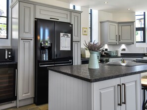A modern kitchen with a built-in refrigerator, a water dispenser, and a granite countertop. - 5 bedroom accommodation in Ramsgate (Ramsgate)