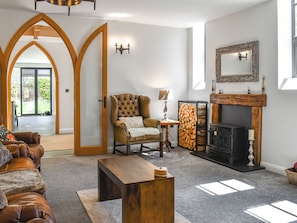 A living room with a fireplace, a leather sofa, a wooden coffee table, and a door leading to a balcony.