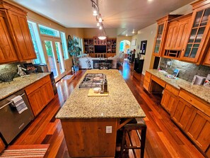 A spacious kitchen with wooden cabinets, a granite countertop, and a central island. - Wine Region Country Home (Sherwood)