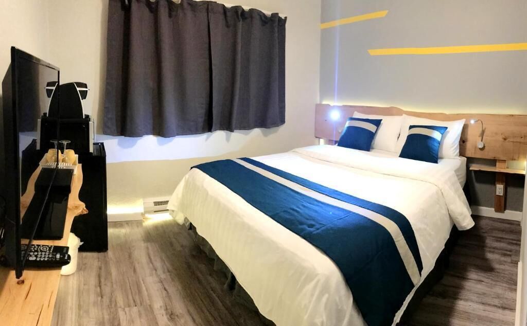 Une chambre d’hôtel équipée d’un lit, d’une télévision et d’une machine à café.