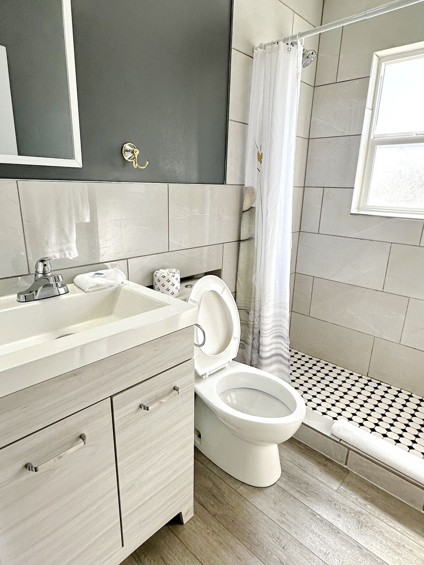 A modern bathroom with a white sink, vanity, and toilet.