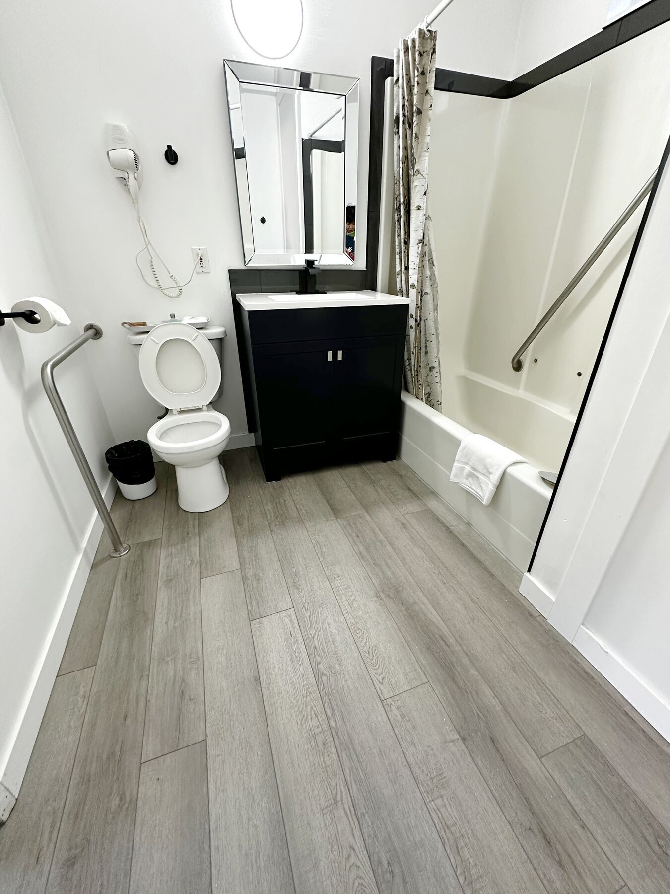 Un baño moderno con inodoro, lavamanos y zona de ducha.