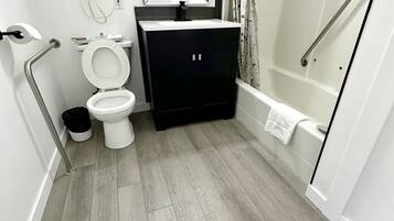 Un baño moderno con inodoro, lavamanos y zona de ducha.
