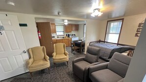 A hotel room with a kitchenette, two armchairs, a sofa, and a bed. - Stay at this Port Clinton guest unit w/boat/trailer parking & plug in, AC, WiFi! (Port Clinton)