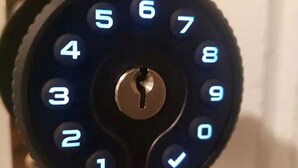 Een close-up van een keypad slot met verlichte cijfers en een centraal sleutelgat.