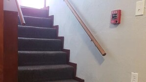 Een trap met een brandmelder aan de muur.