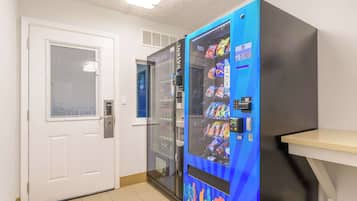 Una máquina expendedora con aperitivos y una puerta con ventanal.